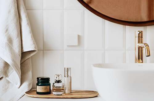 afbeelding van een waskom met gouden kraan en badkamer accessoires